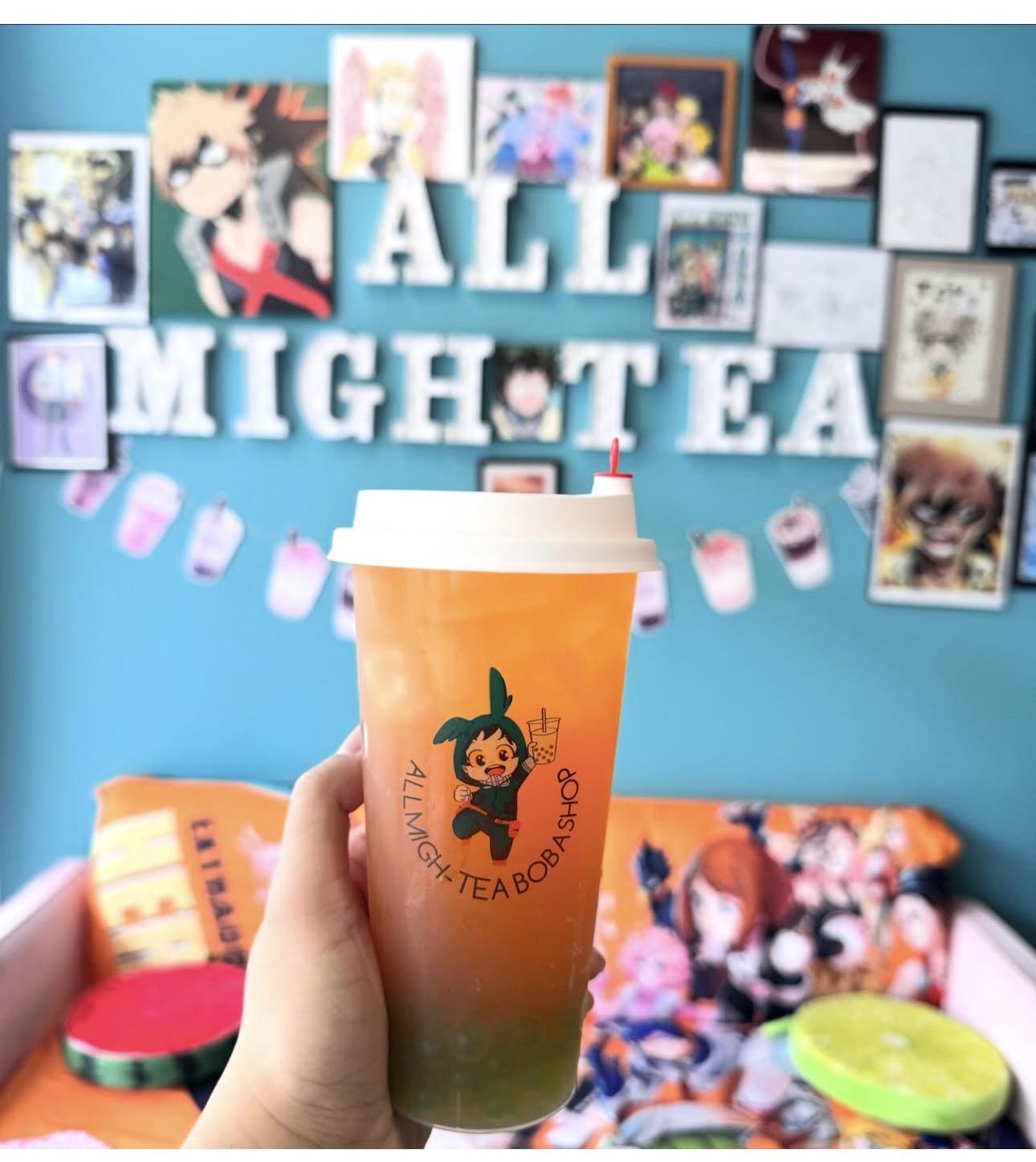 Fruit tea with All Migh-Tea logo in the anime-decorated shop